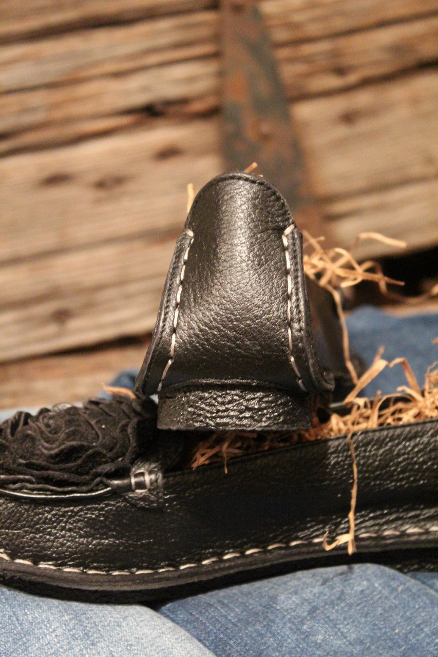 black leather loafer with flower rosette on toe