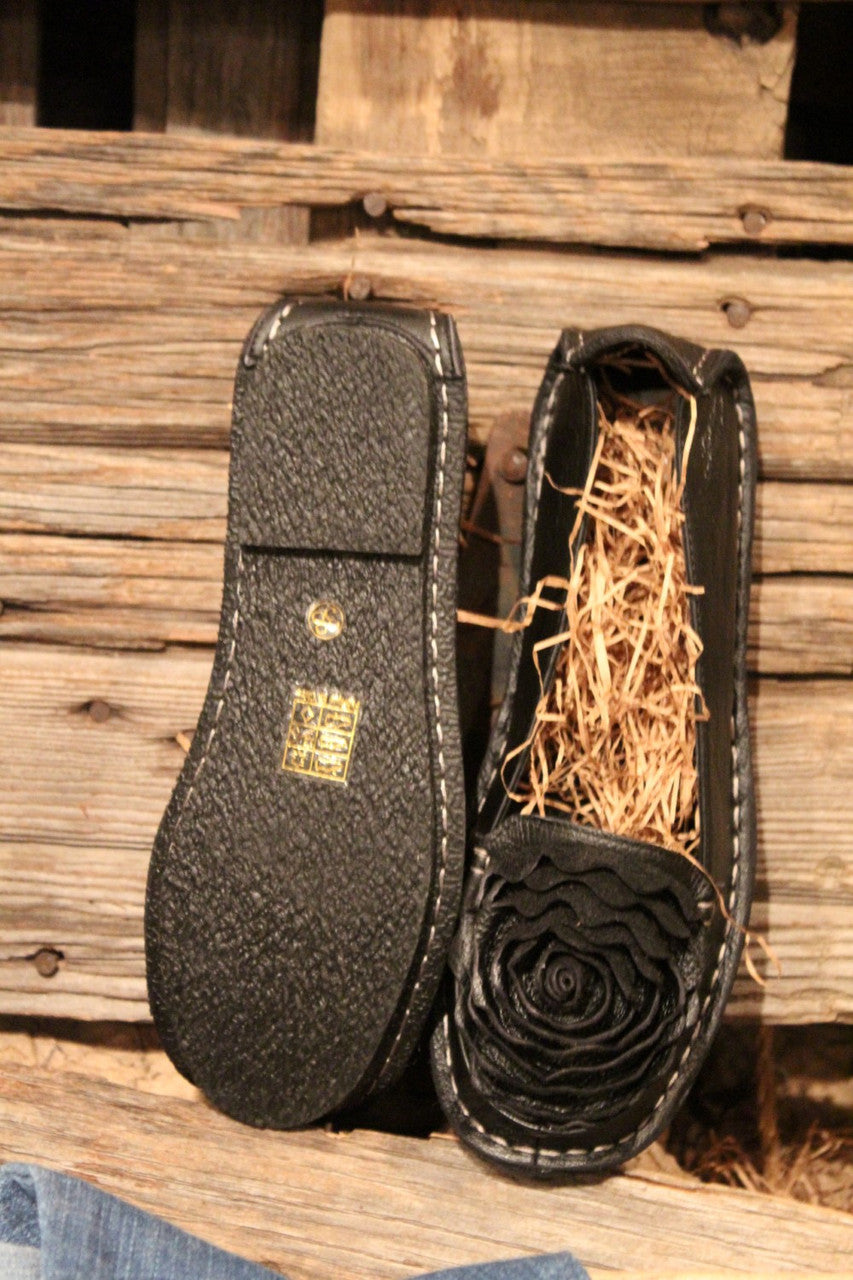 black leather loafer with flower rosette on toe